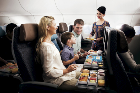 Frau, Kind, Mann mit Stewardess während des Essens mit Singapore Airlines